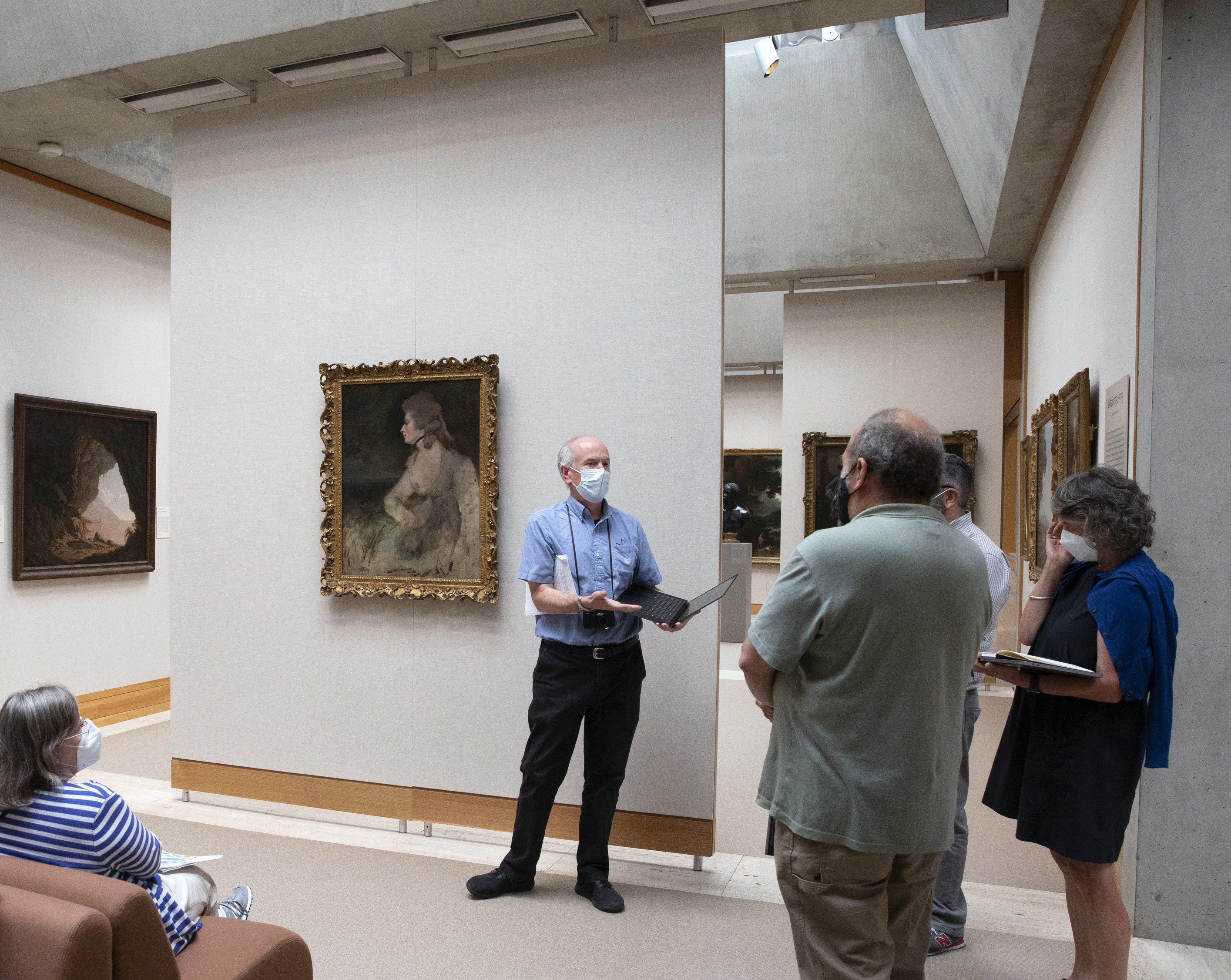 One STITAH participant standing and presenting inside the YCBA next to the original painting in Fig. 6 with other participants listening.