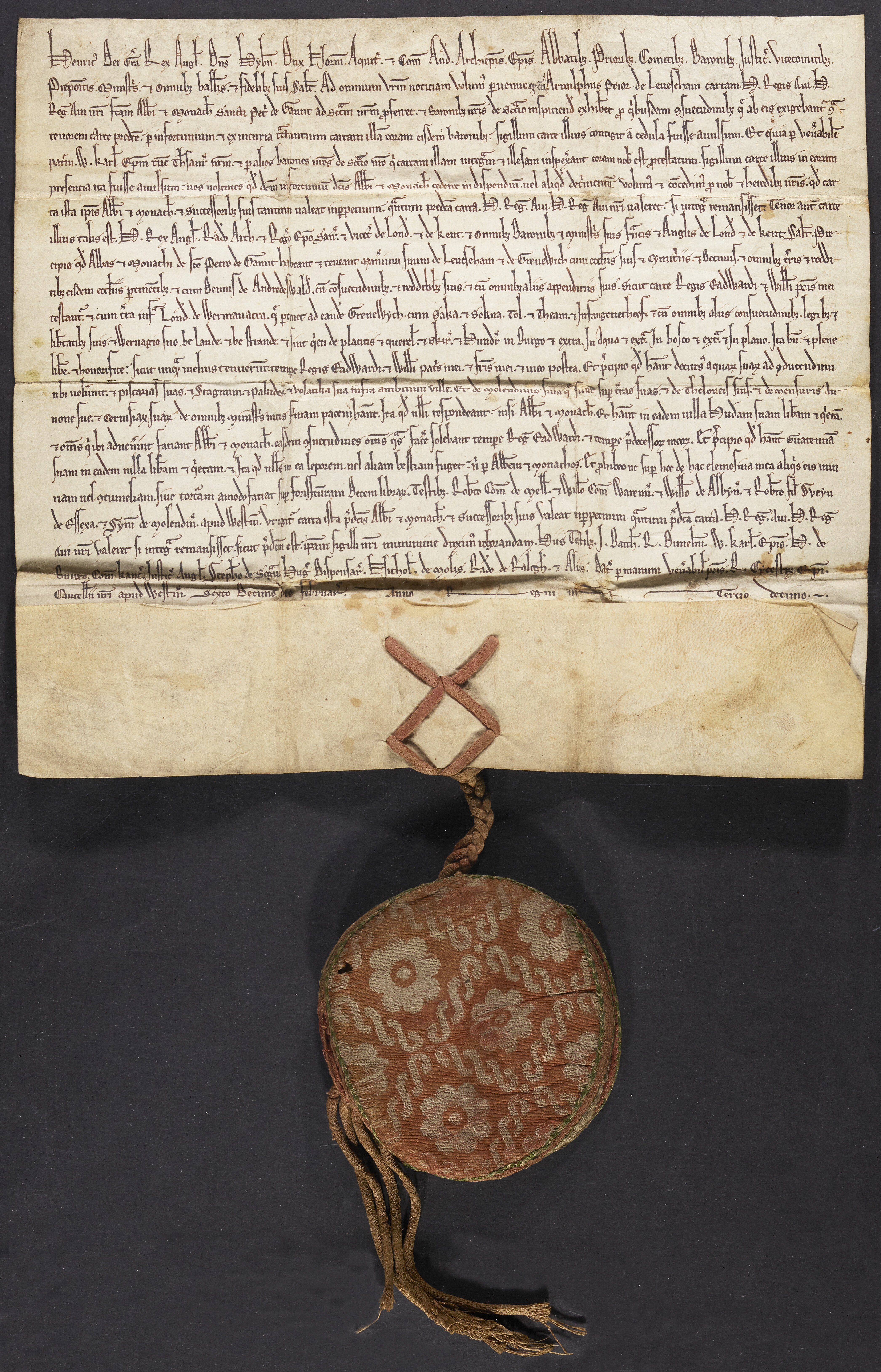 Parchment charter (Lewisham) with its seal enveloped in a red-pinkish silk wrapper decorated with white flower medallions.