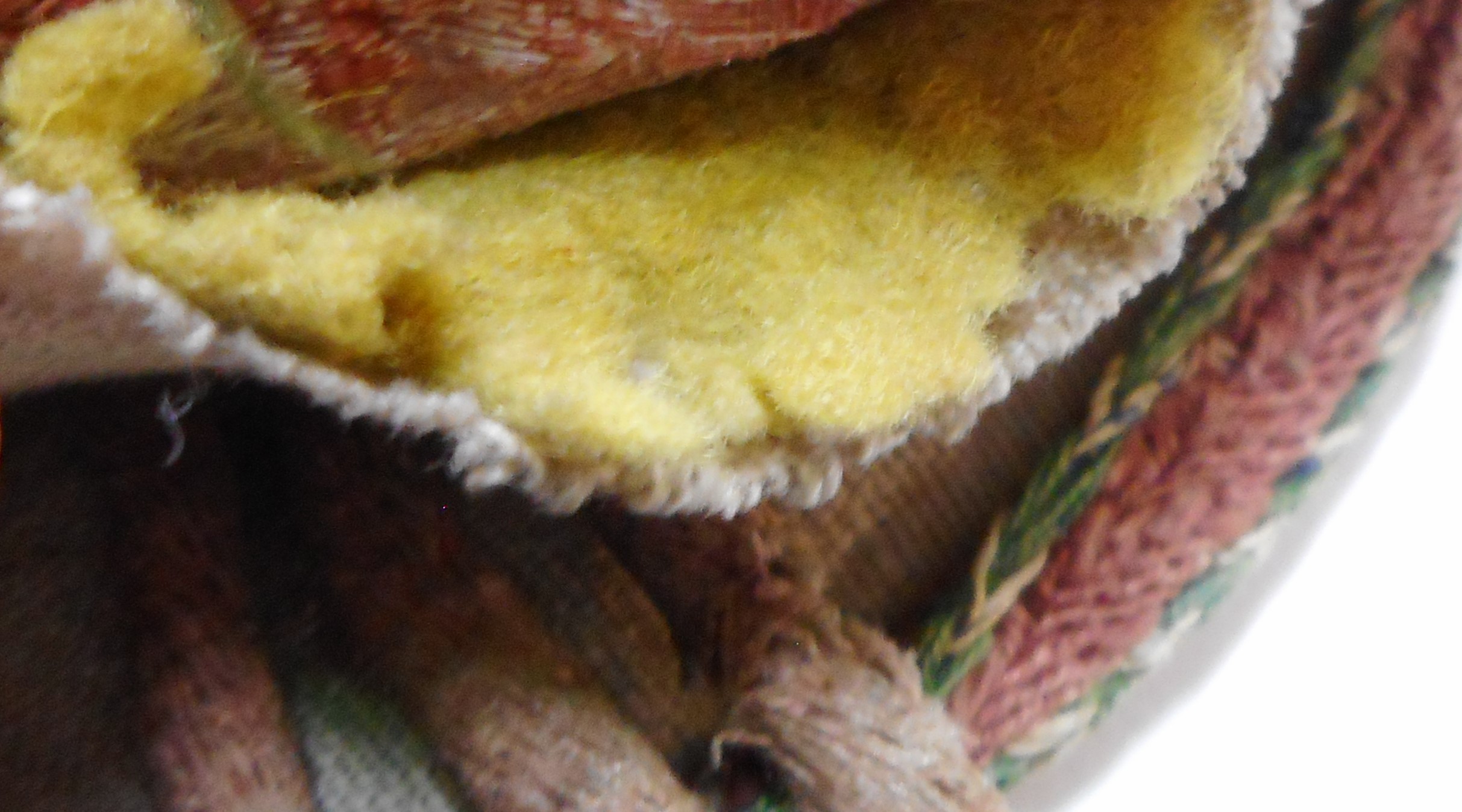 Microscopy detail of the yellow felt padding of the red-pinkish seal bag.