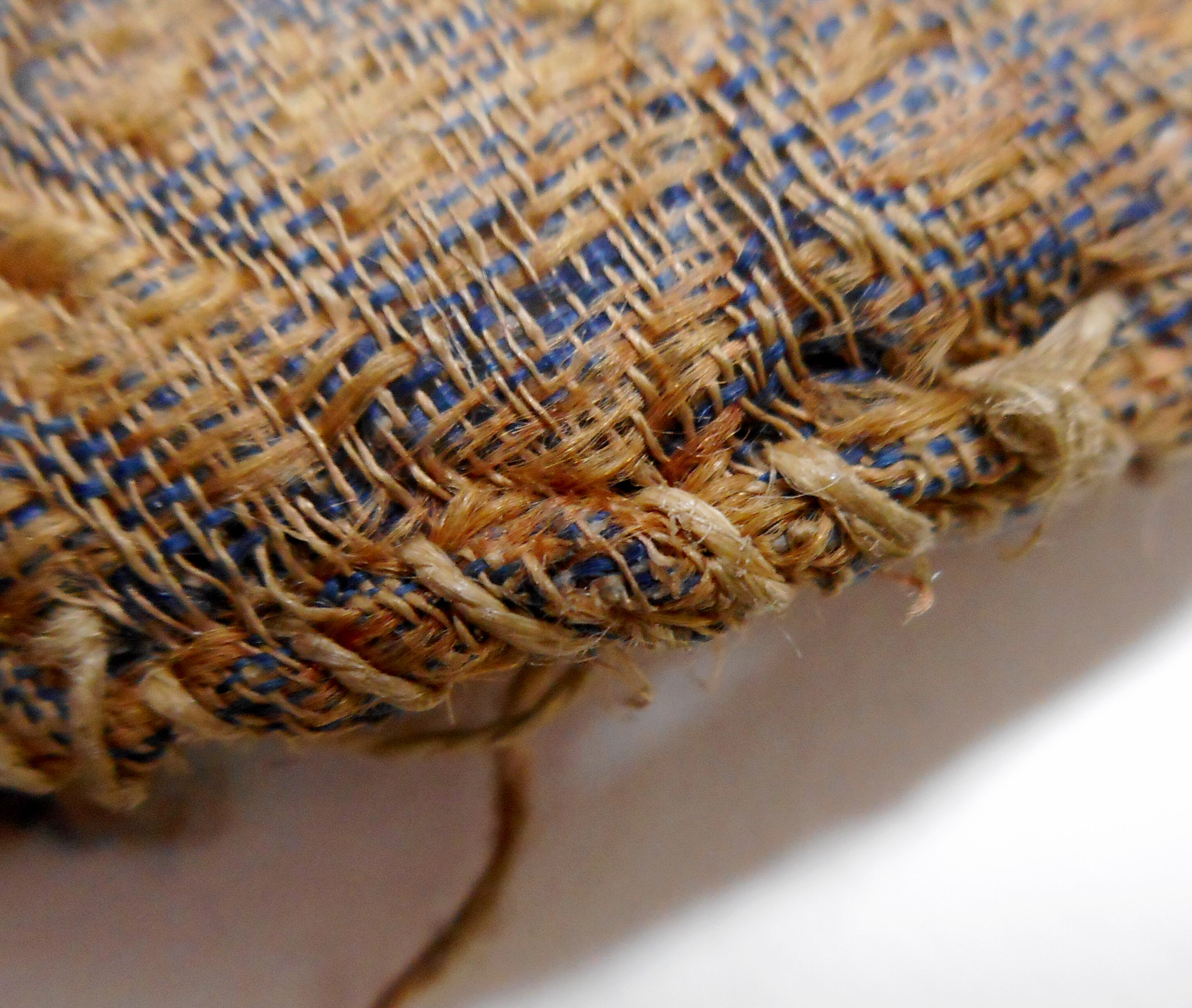 Close-up detail of the edge of the seal bag showing untidy stitching.